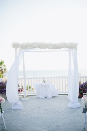 Chuppah With White Curtains and Flowers