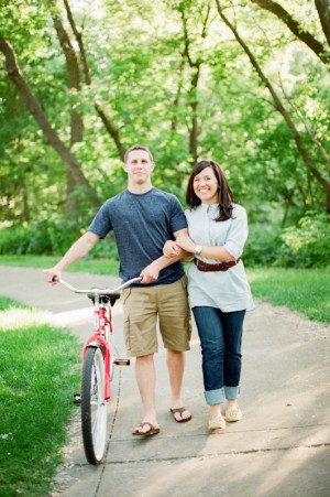 Couple Walking in Park With Red Bike