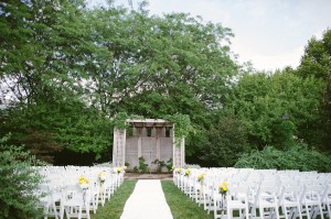 Outdoor Ceremony Site With White Chairs and Yellow Flowers