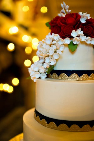 Round Tiered Wedding Cake With Gold Leaf and Red Roses