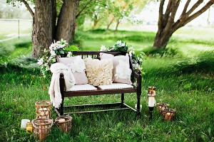 Bench in Grassy Meadow With Pillows Blanket and Candles1