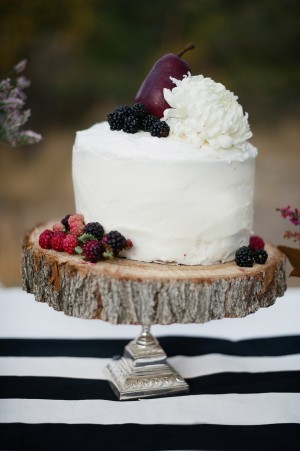 Round White Cake With White Flower and Berry Garnish