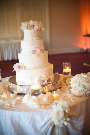 White Wedding Cake With Flowers on Silver Stand