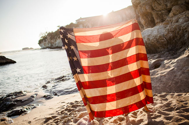 Couple Holding American Flag on Beach