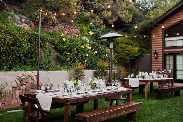 Outdoor Reception With Warm Wood Tables and Cream Decor