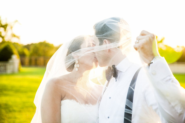 Bride and Groom Kissing Under Veil