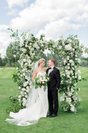 Bride and Groom with Ornate Floral Arch